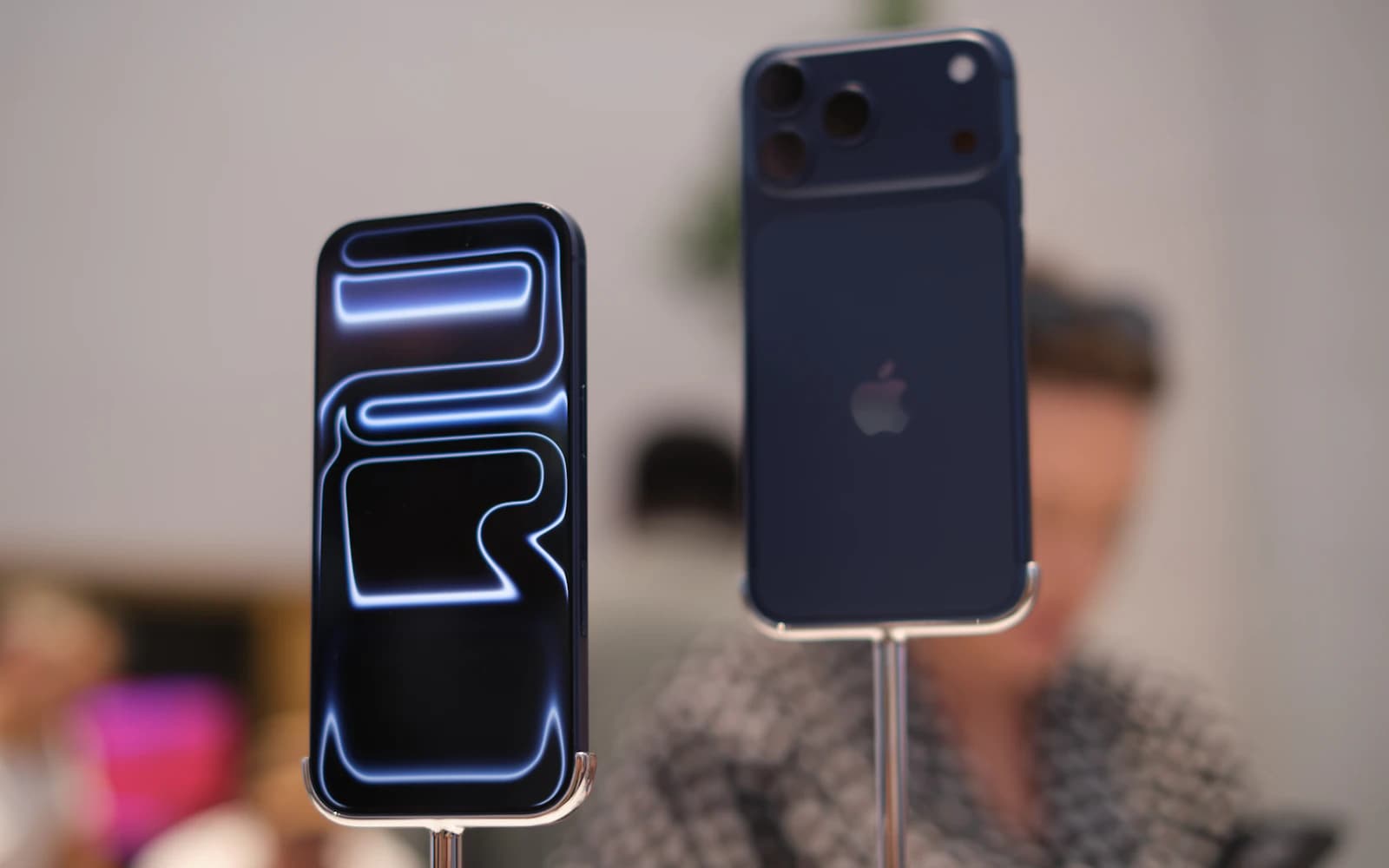 Two smartphones displayed side by side in a technology exhibit
